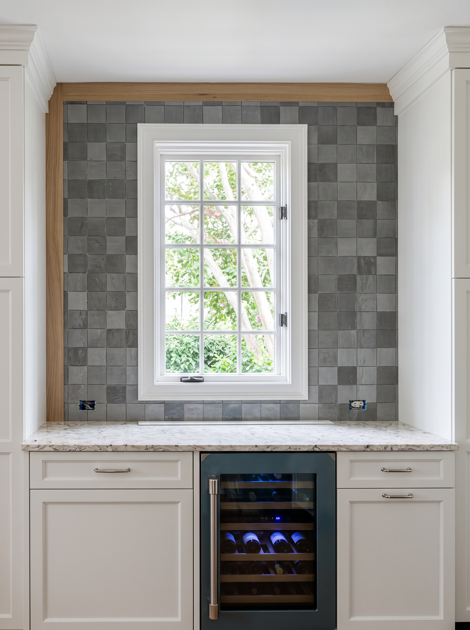 Wet bar with grey glazed tile, stone counter, and wine refrigerator